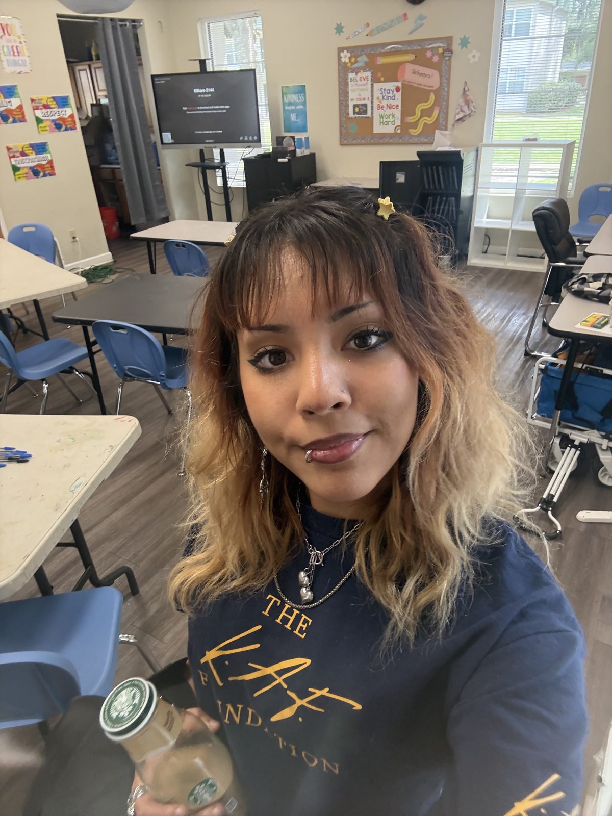 A Creator Bound Apprentice in a navy KAF Foundation shirt, assisting at a photography class